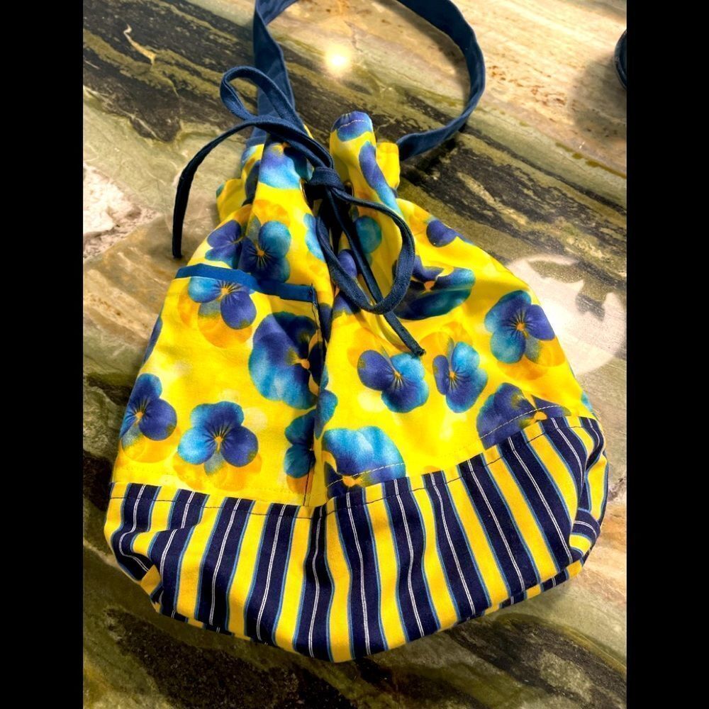 Drawstring hobo bag with blue violets and opposing striped print.